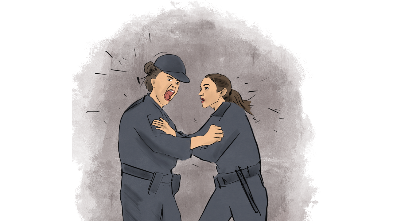Two female corrections officers shouting at a each other